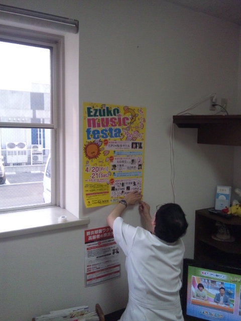 "ゆめさくら"のポスターを待合室に貼る塚本和彦院長